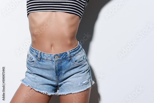 Woman wearing stylish denim shorts on white background, closeup. Space for text