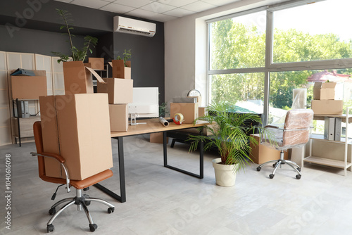 Workplace with chairs and cardboard boxes in office on moving day