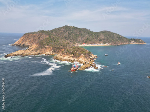 Aerial view of La Roqueta Island and a boat parked on the island, in Acapulco, Mexico