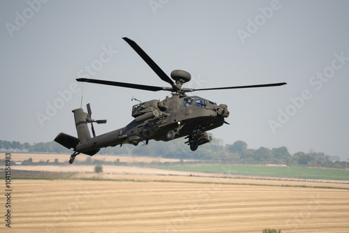 close-up front-quarter view of a British army Boeing Apache Attack helicopter gunship AH64E AH-64E ArmyAirCorp in low level banking flight