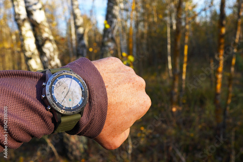 Smartwatch travel. Hiker checking the map altimeter on sports watch. Adventure and Expedition with smartwatch. Watch for survival in wild. Outdoor and hiking Watch on hand. Tactical GPS Smartwatch.