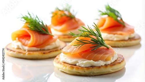 Delicious smoked salmon blinis with cream cheese and fresh dill on white background