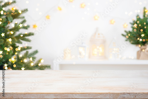 Front view of Christmas table top with blurred fir tree and winter holiday decoration background