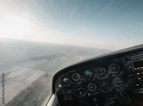 Point of view: piloting small aircraft. Cockpit of light utility aircraft - instrument panel with numerous gauges. 