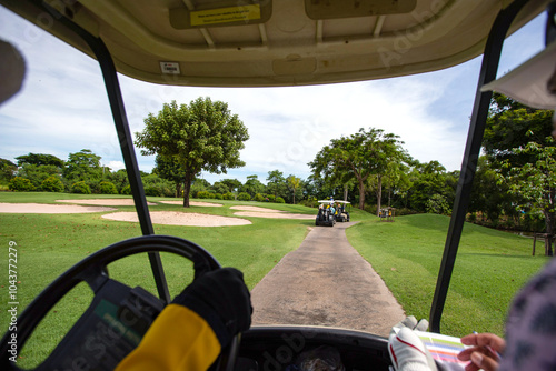 a white golf ball on a tee and a green field ready to be hit with a wood golf stick as a start to a game of golf.