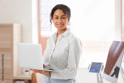 Young African-American QA engineer working with laptop in office