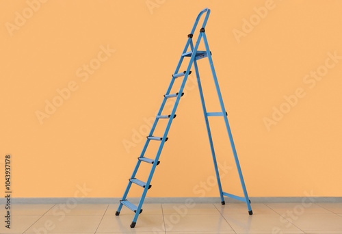 Blue stepladder near orange wall