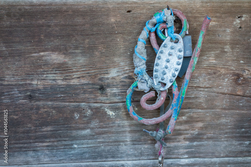 A weathered fishing net and metal anchor against rustic wooden planks.