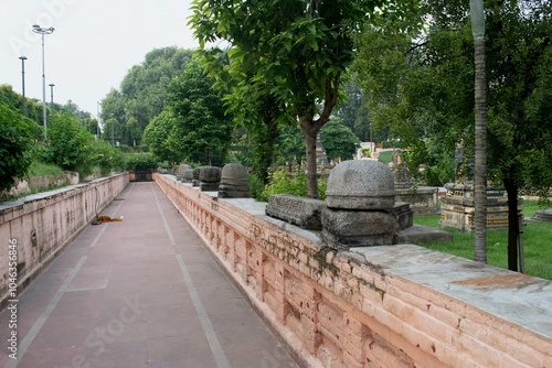 ancient stone structures and the pathway surrounding the "stupa" or relic structures consist arranged garden at mahabodhi temple, bodh gaya, bihar, india