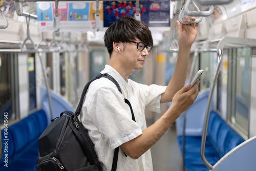 電車内でスマホを操作する男性