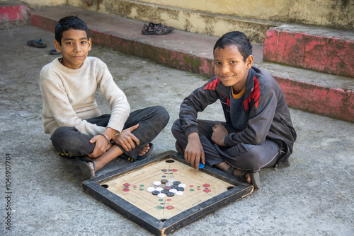 Indian village boys focus intently on a carrom board while playing together in a courtyard, surrounded by pastel-colored walls and a calming atmosphere.