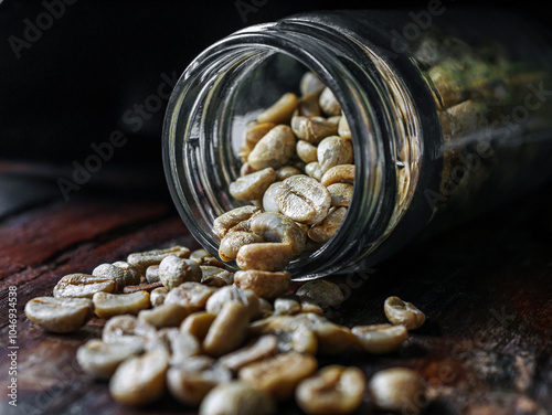 Green coffee beans poured out of a glass jar, Close-up of green raw coffee bean, unroasted coffee bean