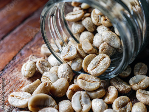 Green coffee beans poured out of a glass jar, Close-up of green raw coffee bean, unroasted coffee bean