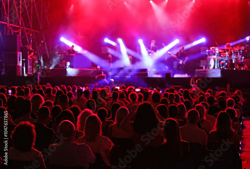 many spectators heads during a live concert with stage lights shining during the artists performance