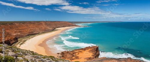 A serene and vast expanse of rugged coastline at Cape Lambert in Western Australia, with the iron ore mines and the Indian Ocean meeting in a dramatic display of natural and industrial contrasts.