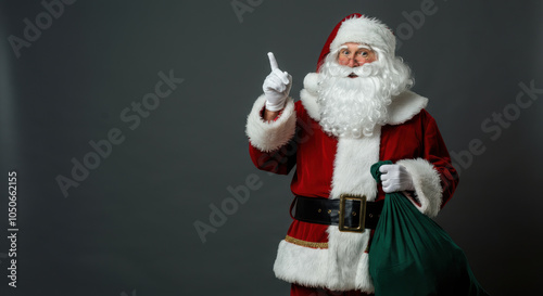 santa claus appointing for copy space beside, smile face, bag of gifts in the ground