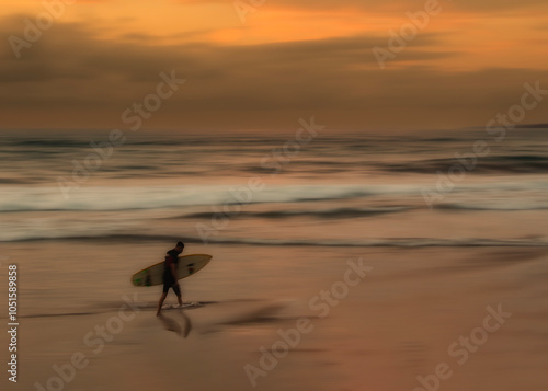 fine art photography surfer coming out of the water at sunset