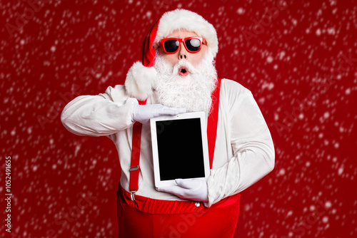 Portrait of his he attractive amazed stunned fat white-haired Santa holding in hands ebook gadget pout lips sale isolated bright vivid shine vibrant red burgundy maroon color background