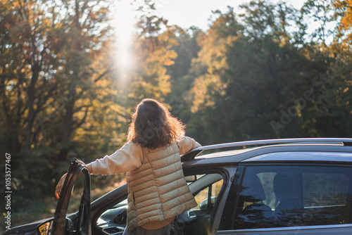 Happy woman driver traveling by car in forest enjoying freedom and nature