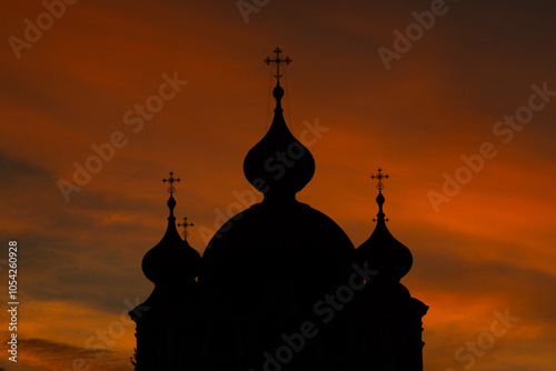 Silhouette of an Orthodox church against the background of the setting sun.