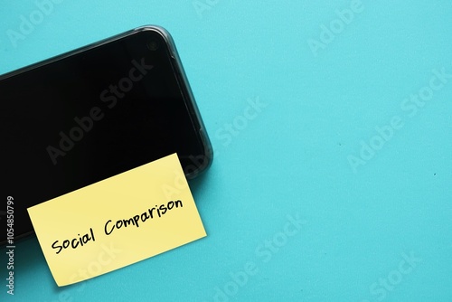 Mobile smartphone with stick note written Social comparison - people value their personal and social worth by assessing how they compare to others - leads to unrealistic benchmark or low self-esteem