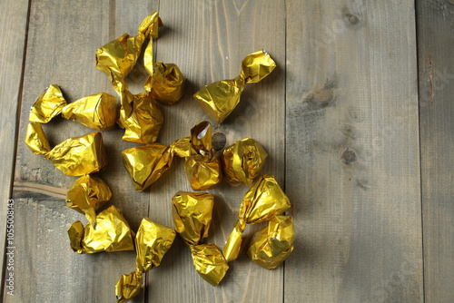 Scattering of candies in a wrapper on a gray background, top view, upper angle. Healthy candies