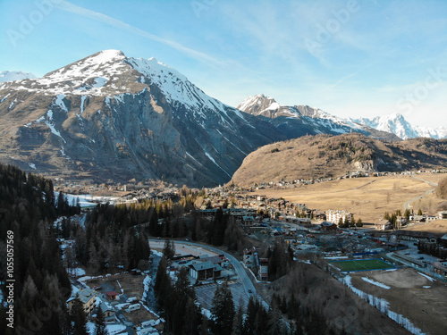 Aerial view of La Thuile ski village, with snowy mountain peaks in the background on a beautiful sunny morning