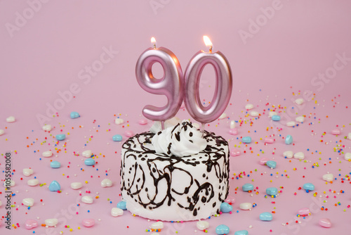 Birthday cake with burning candles on pink background. Number 90.