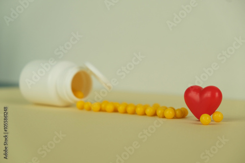 Yellow dragees poured out of a plastic jar on a white background close-up