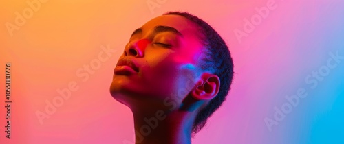 Profile portrait of young woman on purple neon studio backdrop