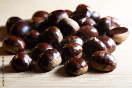 Autumn fresh raw shiny chestnuts on a wooden table