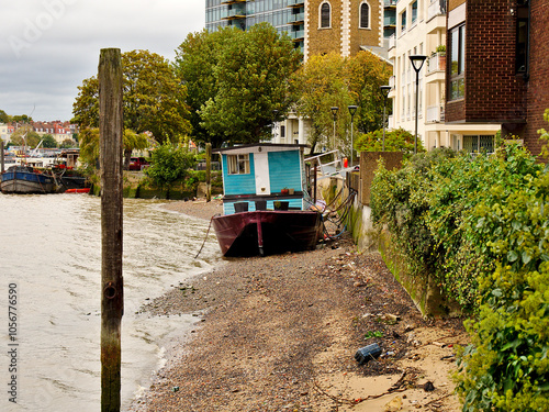 A boat on the margins of the river Thames, London, UK.