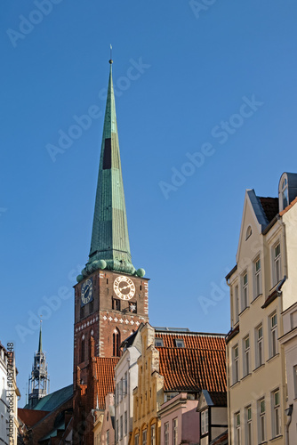 Turm der Kirche St. Jakobi in der Altstadt von Lübeck, Deutschland, der neben den Giebeln alter Häuser emporragt