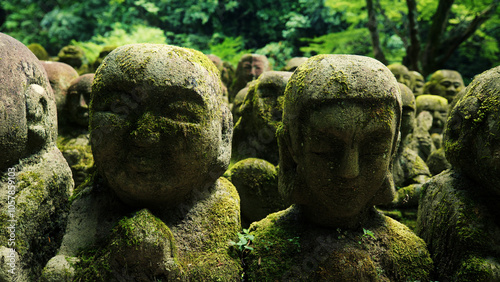 Silhouette of small, ancient Buddha statues outside - Japan