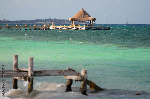 Rustic pier with thatched hut over turquoise waters in Puerto Morelos