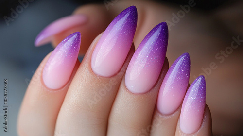 Elegant ombre nails from pink to purple with glitter on almond-shaped tips.