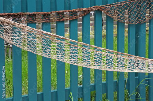 Old fishing nets on a blue wooden gate.