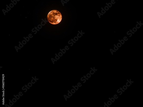 A striking image of a red moon shining brightly in the night sky, casting an eerie glow over the landscape below, glow, astronomy