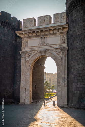 Beautiful evening photo with strong sunshine backlight of Porta Capuana entrance gate to the old town of Napoli old town. Magnificent roman gate in Naples..