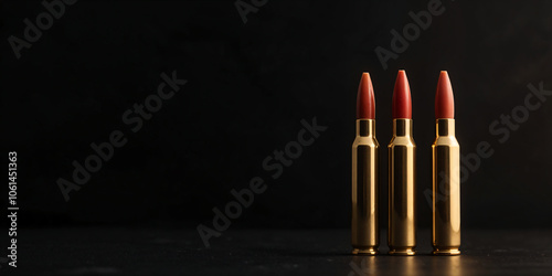 Close-up image of a bullets with isolated on a dark background Three bullet heads made from red lipstick No.007