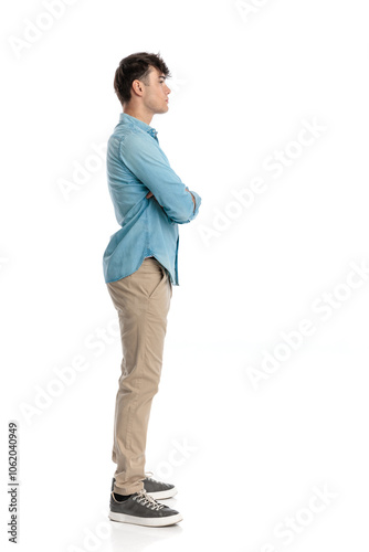 casual young man standing in line with arms crossed confidently