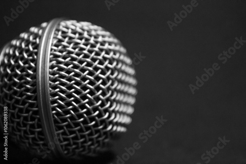 Concert microphone, metal grid, Dynamic microphone head for concerts on stage, singers, presenters. News, performances, stand-up, music, creativity. Black and white background. Close-up