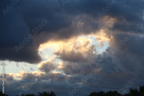 Nubes grises y blancas del atardecer, los últimos rayos de sol iluminan los bordes o comisuras de las nubes dándoles un tono cálido y permitiendo la entrada de la luz natural