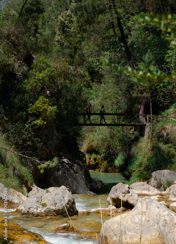 Puente sobre el río con excursionistas pasando.