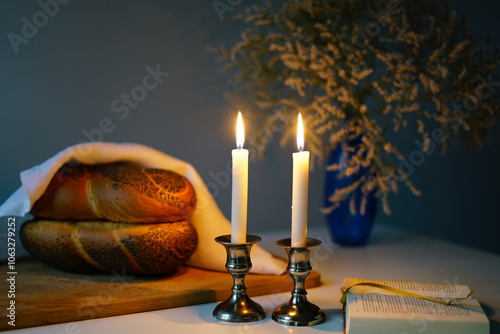 Traditional challah bread with wine and glowing candles on dark background. Shabbat Shalom