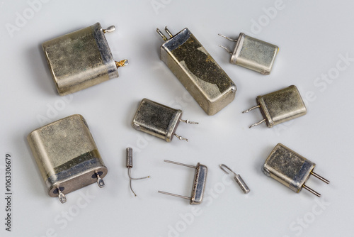 Old different crystal oscillators in metallic packages on gray background