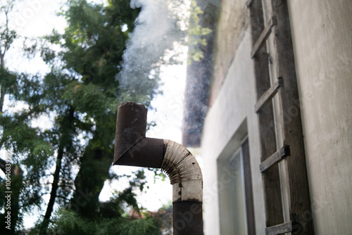 Smoke from an old rusty pipe in the backyard