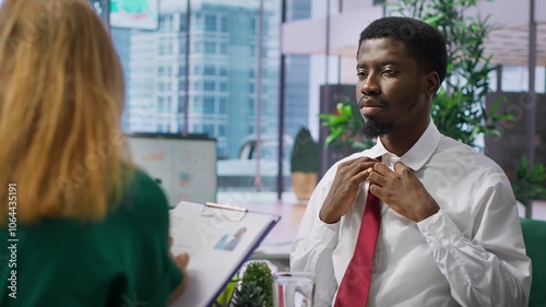 Anxious inexperienced job applicant feeling very uncomfortable during interview, being insecure and overwhelmed while he talks about himself and his qualifications with the HR team. Camera A.