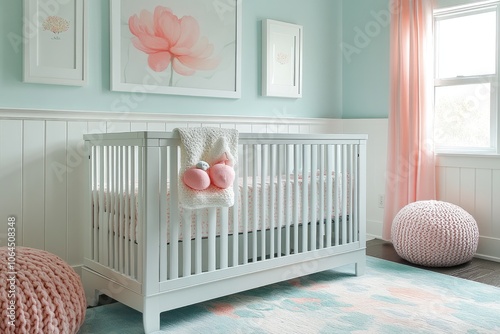 White baby crib in cozy pastel nursery room with peach and mint green accents