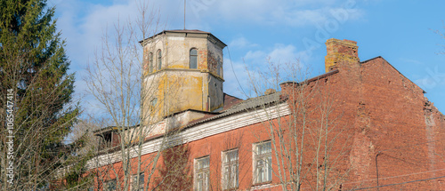 Old factory building made of red brick, in poor condition, located in Krasnofarforny, Leningrad region, Russia.